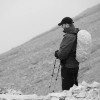 black and white photo of man hiking on mountain