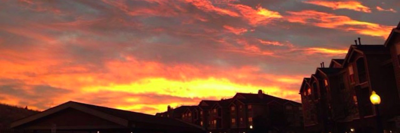 a colorful sky at sunset over a neighborhood