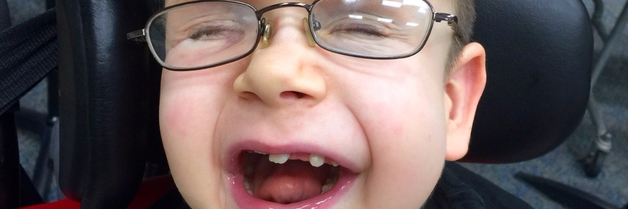 How to Talk to Doctors About My Child With Pfeiffer Syndrome little boy smiling with mouth open wearing glassees
