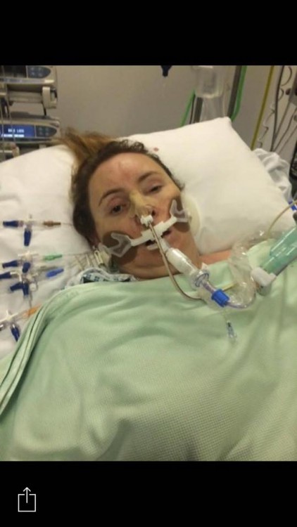 woman wearing mask over nose and mouth in hospital bed