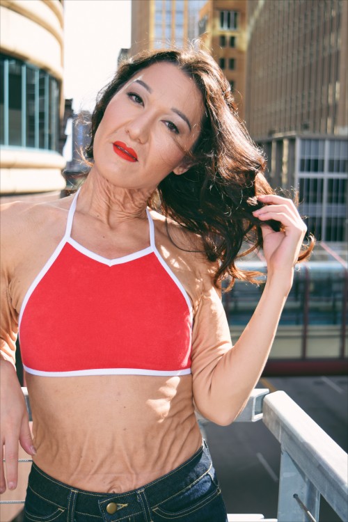 sara geurts modeling in red top on a balcony outside