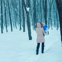 mother taking a walk in the snow with her son