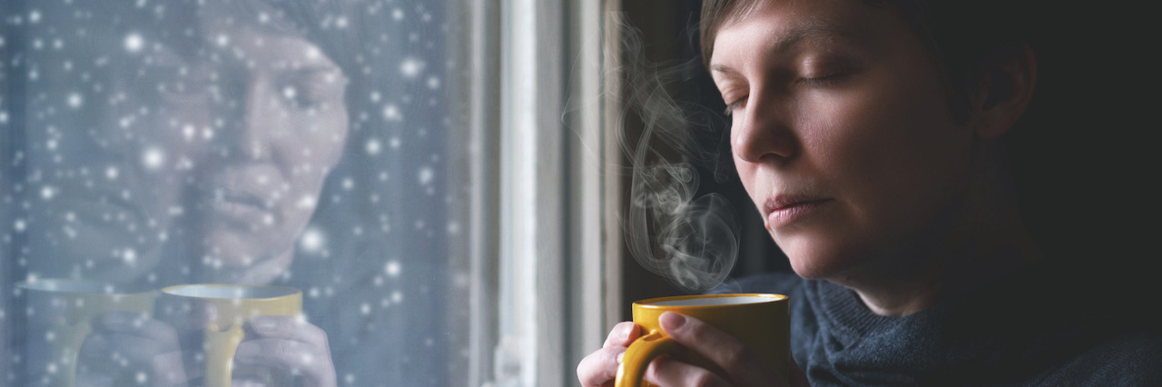 10 Tips From a Psychotherapist to Beat 'The Winter Blues' Lonesome Woman Drinking Coffee in Dark Room