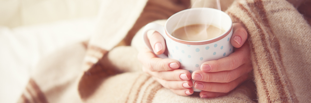How I've Learned to Manage Anxiety and Depression During the Holidays warm cup of hot coffee warming in the hands of a girl