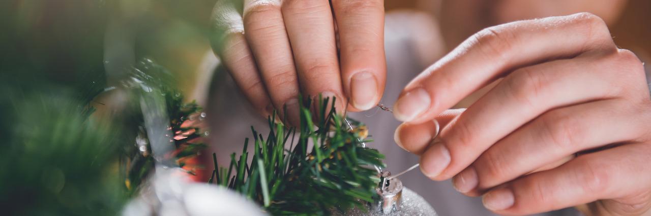 6 Tips for Those in Anorexia Recovery This Holiday Season Woman in brown sweater decorating christmas tree