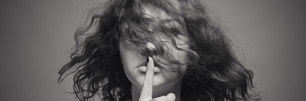 When Someone Said My Self-Harm Was 'for Attention' Melancholic woman holding finger on her face over gray background