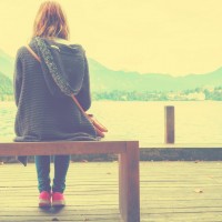 young woman sitting on a wooden pier