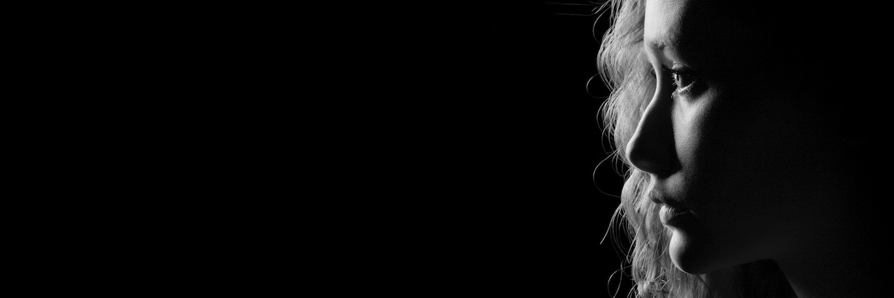 What the Daily Struggle With Anxiety Is Like profile of young pensive woman on black background with copyspace, monochrome