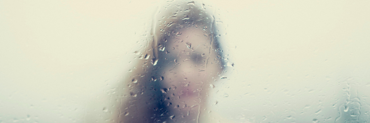 What It's Like to Be Stuck in 'Depression Fog' Blurry image of a woman through a rainy window