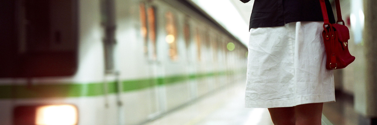 A woman standing on a train loading dock