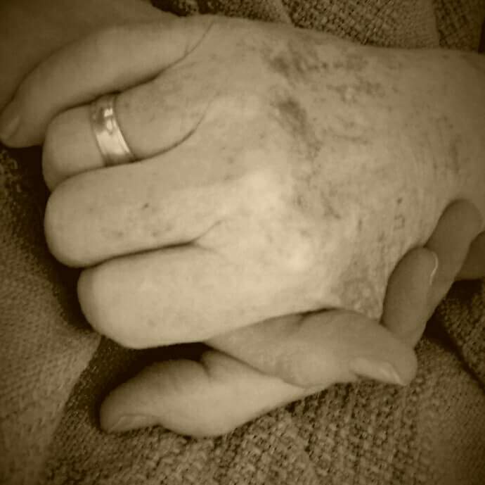 daughter holding her ill fathers hand