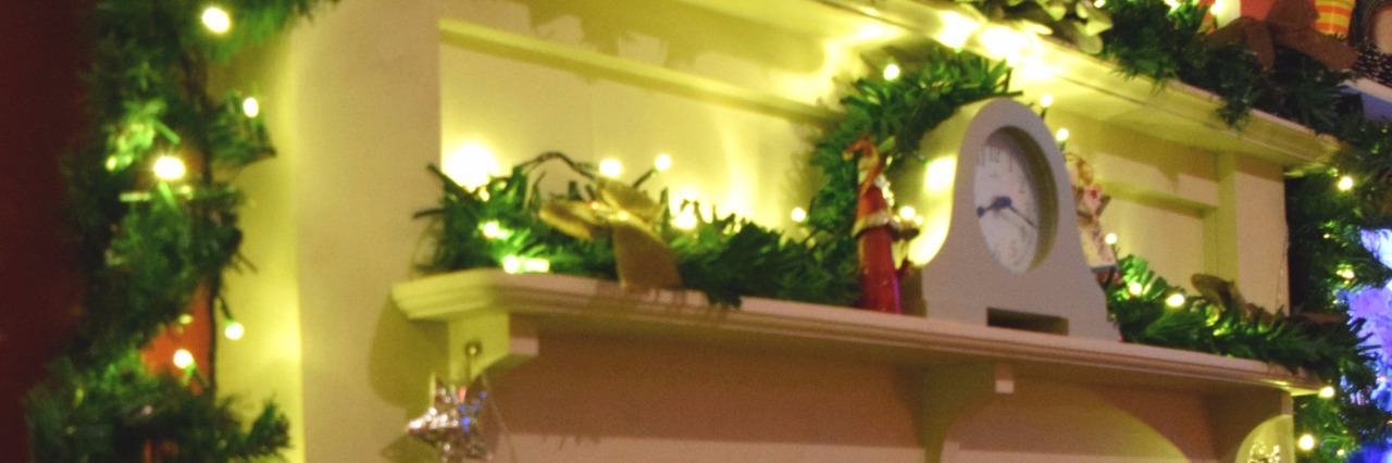 Supporting Friends and Family With Chronic Illness During the Holidays mantel decorated for christmas with garland, ornaments, and a santa