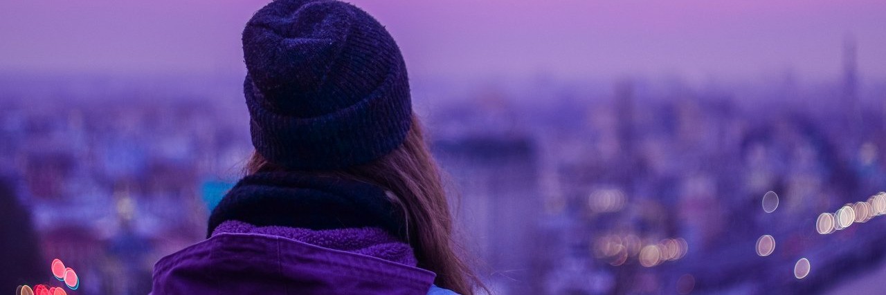 Lessons I've Learned From Having Chronic Lyme Disease traveler with backpack looking at winter evening cityscape