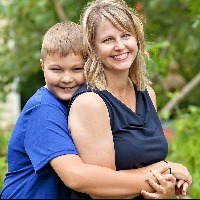 son hugging his mother from behind while posing outdoors