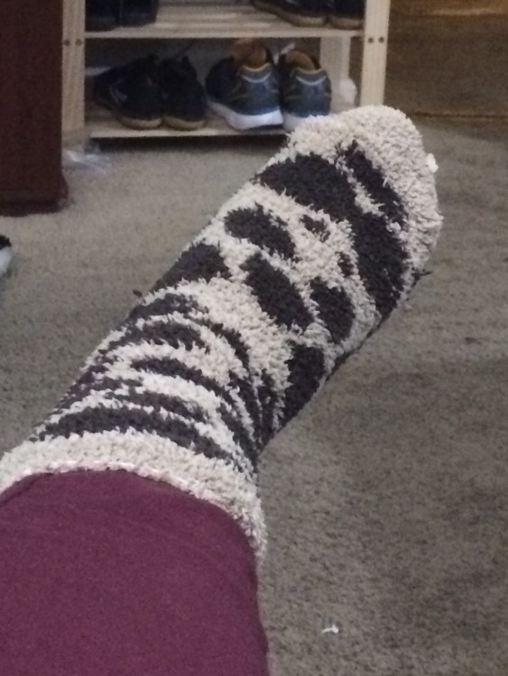 woman's foot with a fuzzy black and white polka dot sock