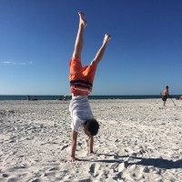 Erin's son doing gymnastics on the beach.