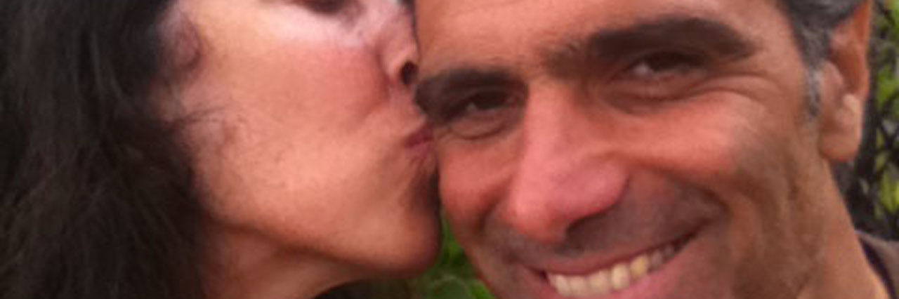 Why My Husband Who Died by Suicide Won't Be Forgotten A woman kiising her husband on his cheek