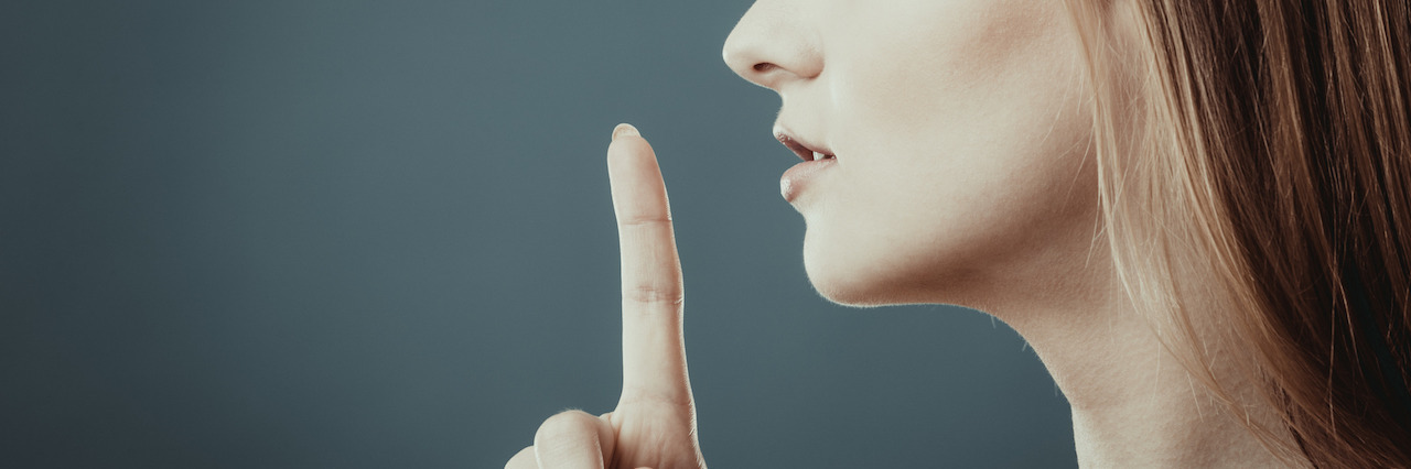 Closeup woman asking for silence or secrecy with finger on lips hush hand gesture, on blue background