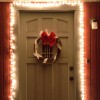 Christmas lights and wreath on front door at night