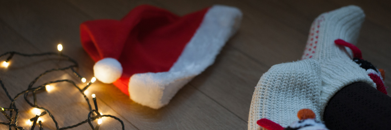 A Letter to People With Eating Disorders During the Holidays The night before christmas. Woman's legs and christmas hat on the floor. Preparation for holiday.