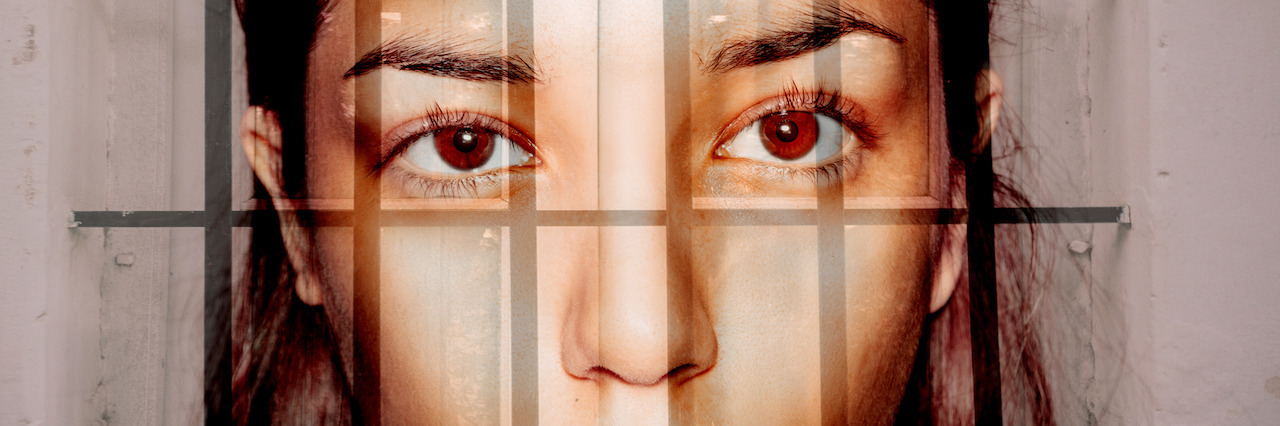 Double exposure portrait of young woman behind the bars