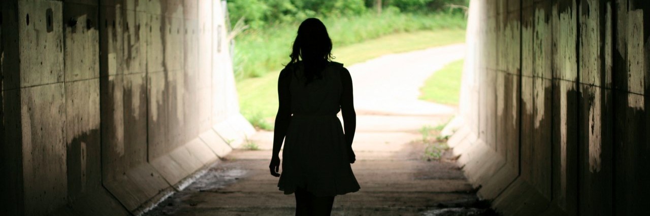 How Living With a Chronic Illness Helps Me Find My Purpose woman walking out of tunnel