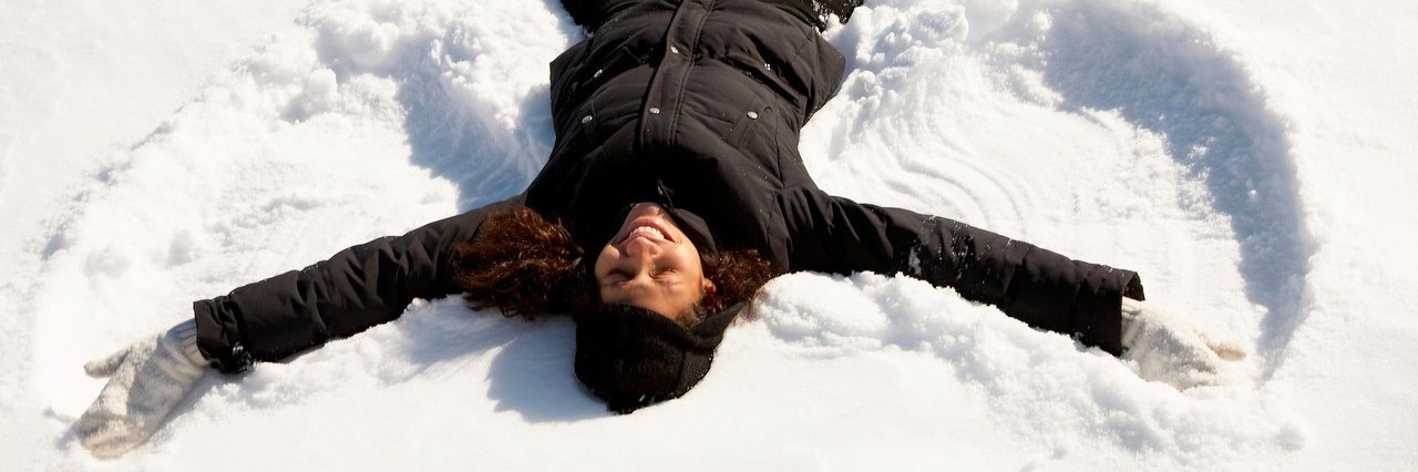 Getting Through Christmas With Fibromyalgia woman making a snow angel