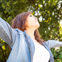A young woman outdoors with her arms outstretched