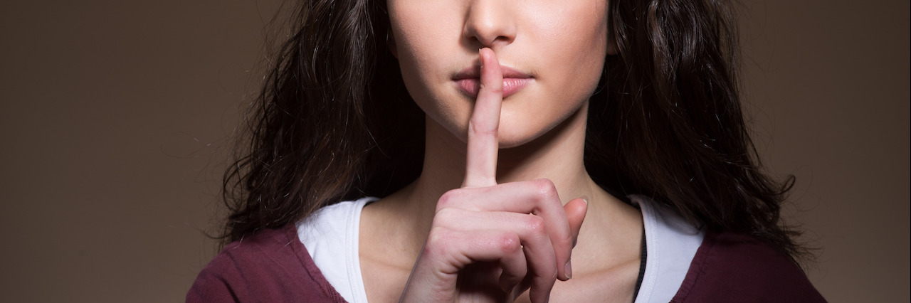 Why People Shouldn't Casually Use the Word 'Crazy' to Label People Beautiful young girl making silence gesture with finger over lips