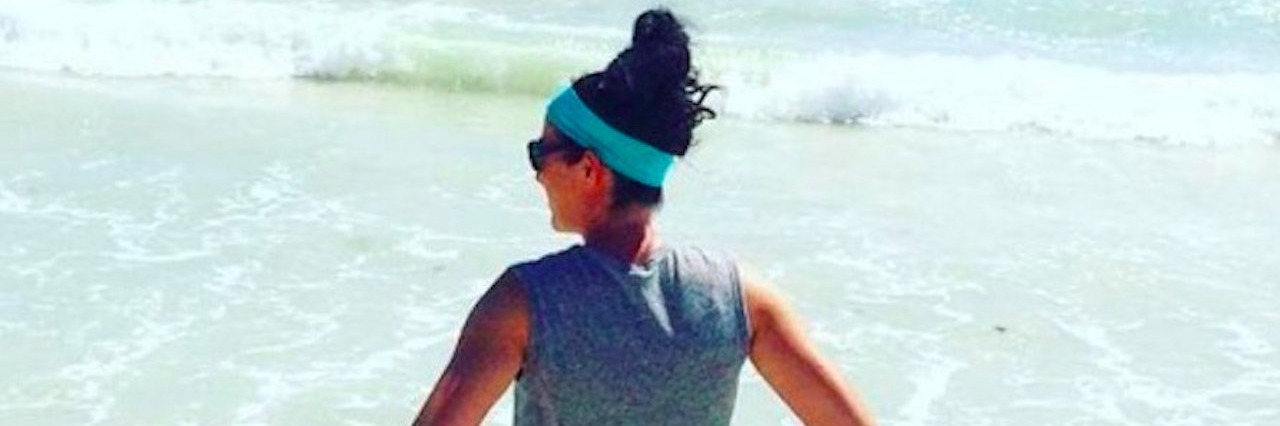 My Pulmonary Hypertension Isn’t an Invisible Illness to Me woman standing on a beach