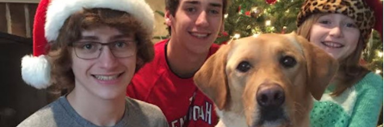Buying Christmas Presents for My Son on the Autism Spectrum The author's children and family dog posing next to the Christmas tree