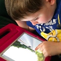 Boy using Google Street Maps view on iPad