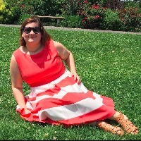 woman in red and white dress sitting on grass lawn