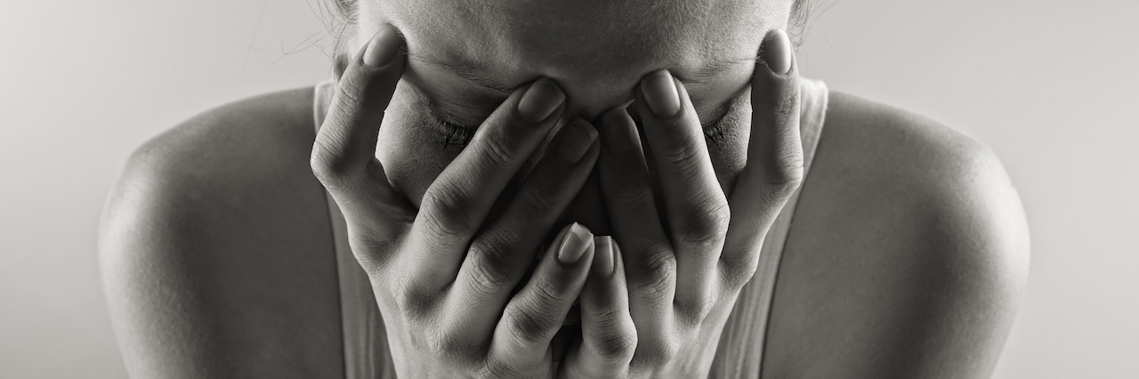 What You Can't See About Living With Mental Illness Black and white photo of a crying woman.