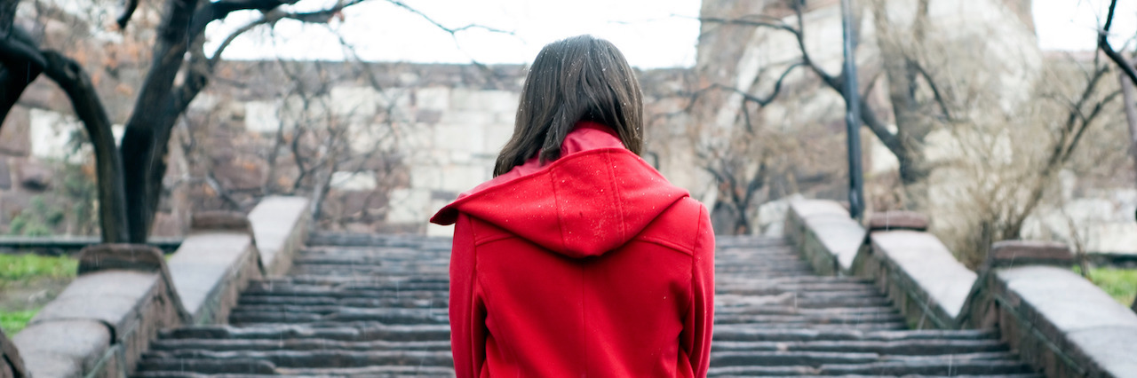 What It Means to Have Anxiety During the Holidays young woman looking towards to the stairs, conceptual photo