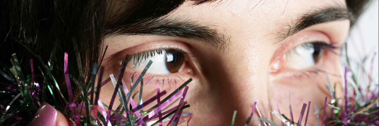 6 New Year's Resolutions for Better Mental Health A woman looking over New Year's decorations