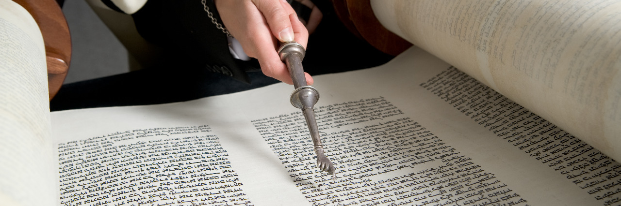 Bar Mitzvah - boy reads Torah scroll.