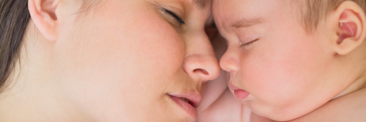 What It's Like to Have 'Hidden' Postpartum Depression Mother and baby sleeping head to head in a bed