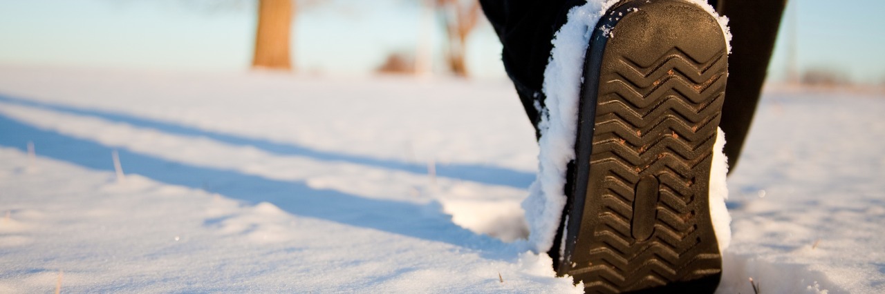 Joint Hypermobility Syndrome and Walking in Snow person in brown boots walking in the snow