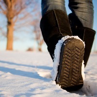 person in brown boots walking in the snow