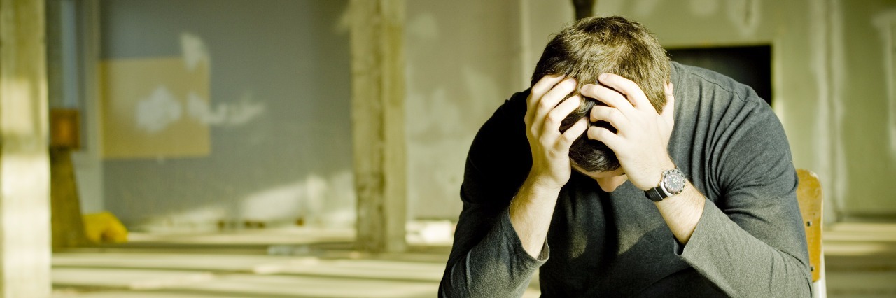 Accepting the Return of Epilepsy in Adulthood depressed young man sitting alone in a deserted building