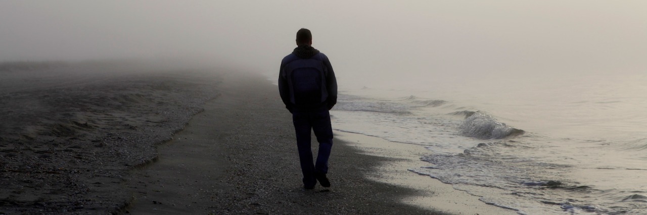 Feeling Bullied By My Grief and What I Realized After Confronting It Man walking alone on a foggy beach