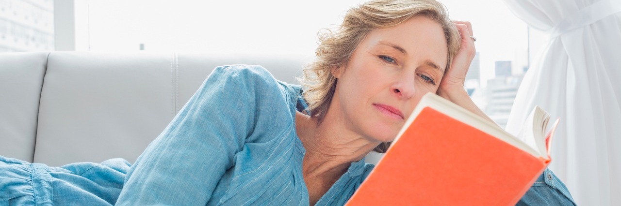 A Note of Encouragement for Mornings You Wake Up Depressed woman reading a book on a couch