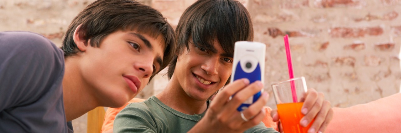 Two teenage boys (14-17) looking at mobile phone