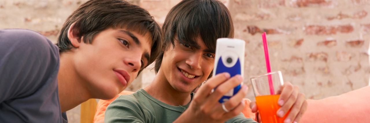 Why Teen Selfies Have the Power to Change How We View Mental Health Two teenage boys (14-17) looking at mobile phone