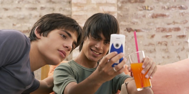 Two teenage boys (14-17) looking at mobile phone