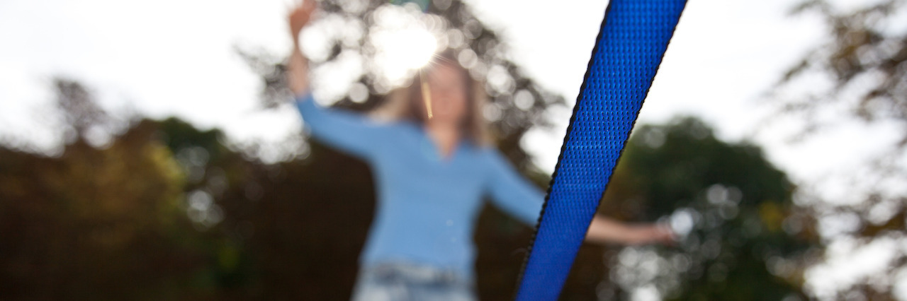 When Bipolar Disorder Is a Balancing Act Woman on Slackline in Parc with focus on slack line