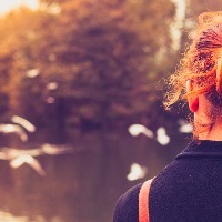 Woman looking at birds flying over water