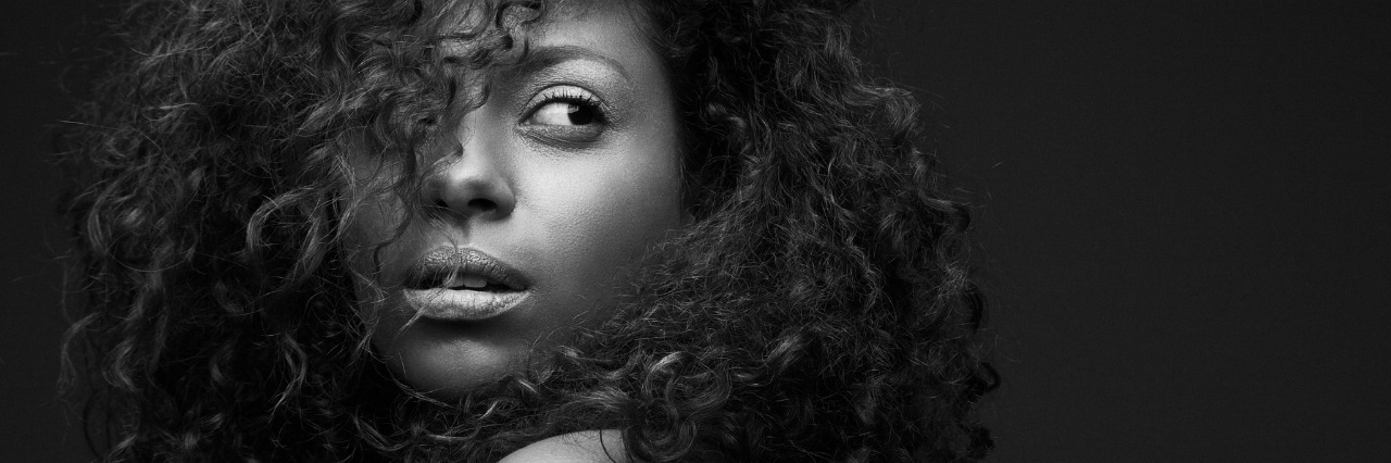 Social and Emotional Effects of Fibromyalgia black and white image of woman with dark curly hair looking over her shoulder