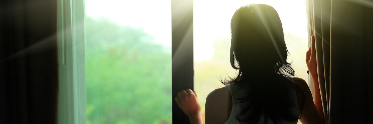 For the People With Mental Illness Who Aren’t Celebrating New Year’s girl opening curtains in a bedroom